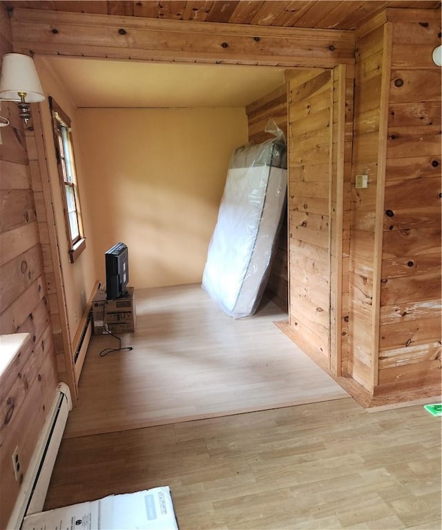 interior space with baseboard heating, light hardwood / wood-style flooring, and wooden ceiling
