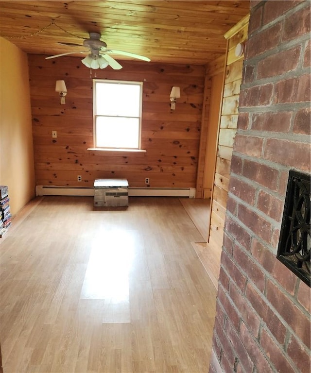 unfurnished room featuring wood ceiling, wood walls, light hardwood / wood-style floors, and a baseboard radiator