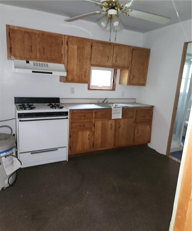 kitchen featuring gas range gas stove, sink, and ceiling fan