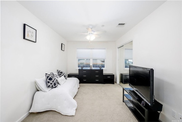 living area with carpet and ceiling fan