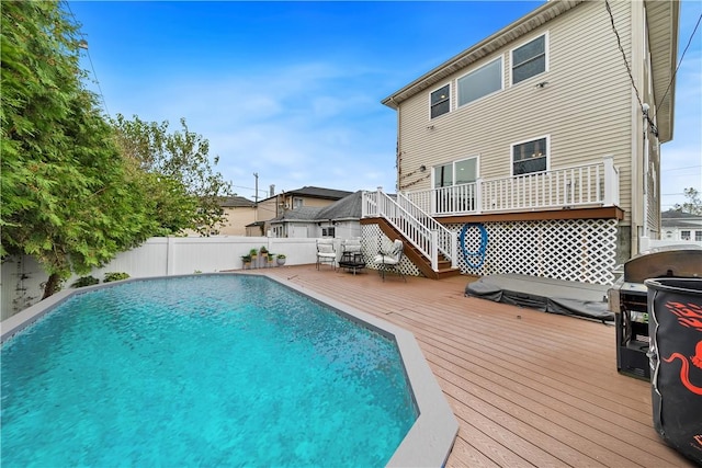 view of swimming pool featuring area for grilling and a wooden deck