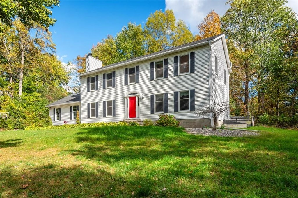 colonial inspired home featuring a front lawn