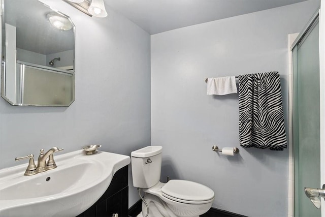 bathroom featuring an enclosed shower, toilet, and sink