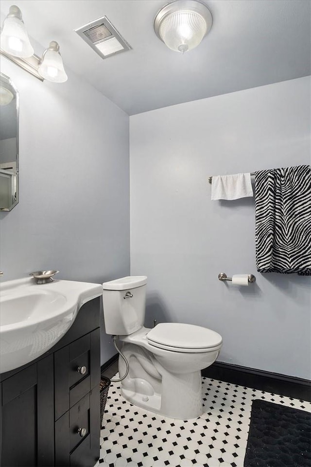 bathroom with tile patterned flooring, vanity, and toilet