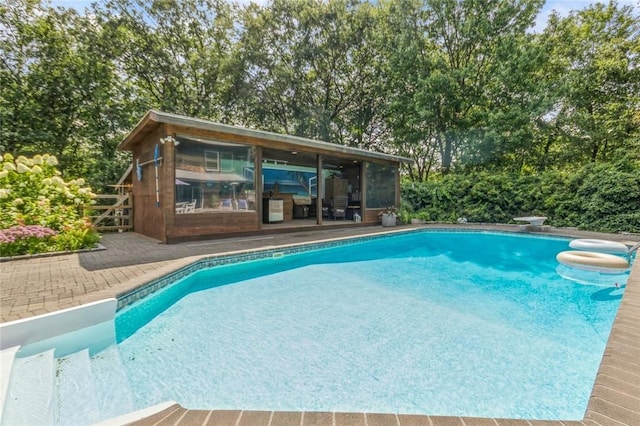 view of swimming pool with a patio and a diving board