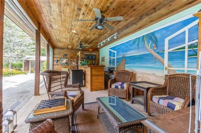 sunroom / solarium with ceiling fan and wood ceiling