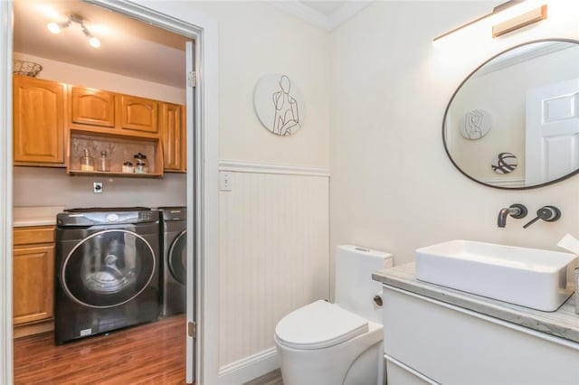 bathroom with vanity, crown molding, hardwood / wood-style flooring, washing machine and dryer, and toilet