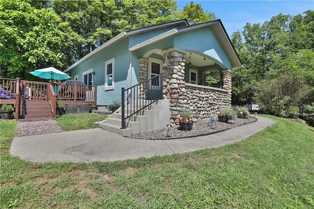 view of front of property featuring a wooden deck and a front yard