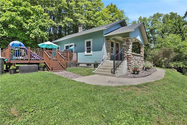 rear view of house with a lawn and a wooden deck