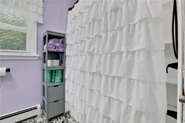 bathroom featuring baseboard heating and a shower with shower curtain