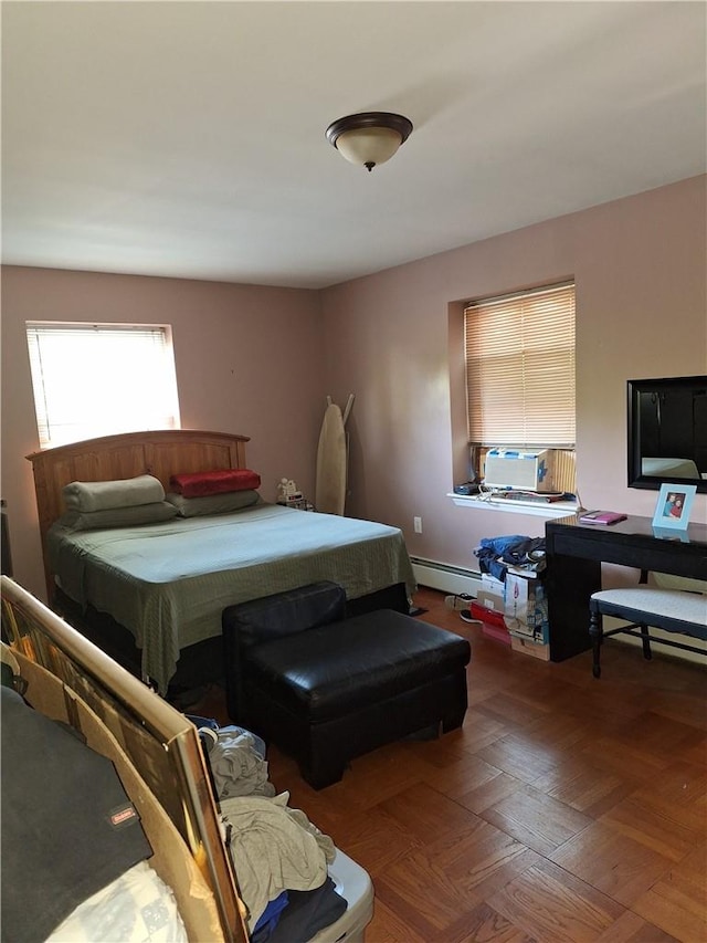 bedroom featuring a baseboard heating unit and hardwood / wood-style flooring