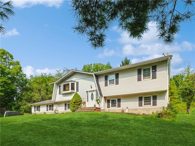 rear view of property featuring a lawn