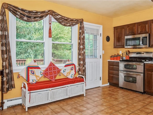 kitchen with dark brown cabinetry, light tile patterned floors, stainless steel appliances, and a baseboard heating unit