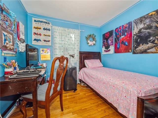 bedroom featuring crown molding and light hardwood / wood-style flooring