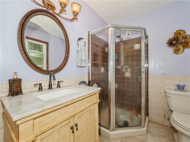 bathroom with tile patterned flooring, toilet, a shower with door, vanity, and tile walls