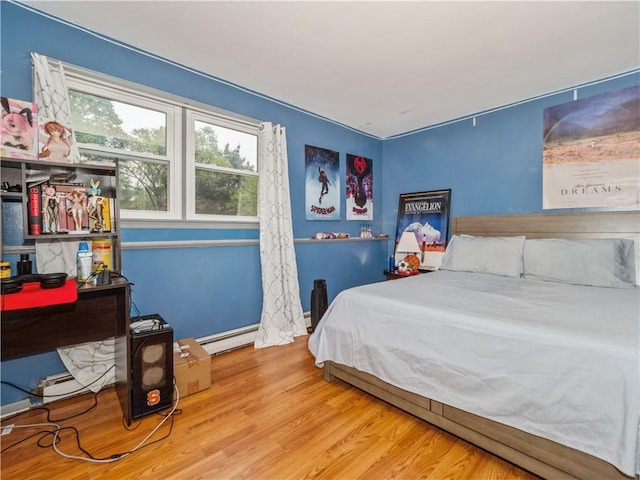 bedroom featuring hardwood / wood-style floors and a baseboard heating unit