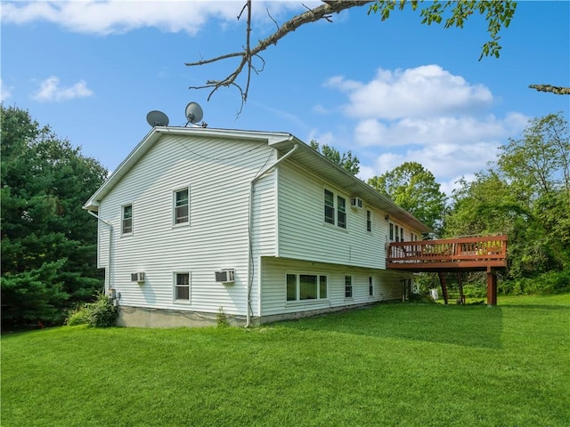 back of property with an AC wall unit, a wooden deck, and a yard