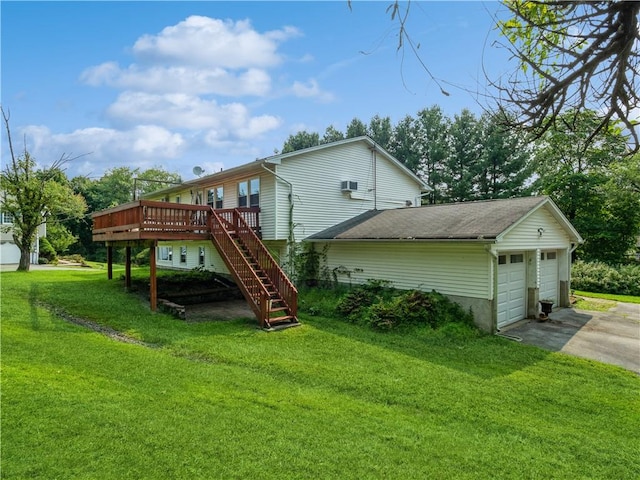 back of property with a deck, a garage, and a lawn