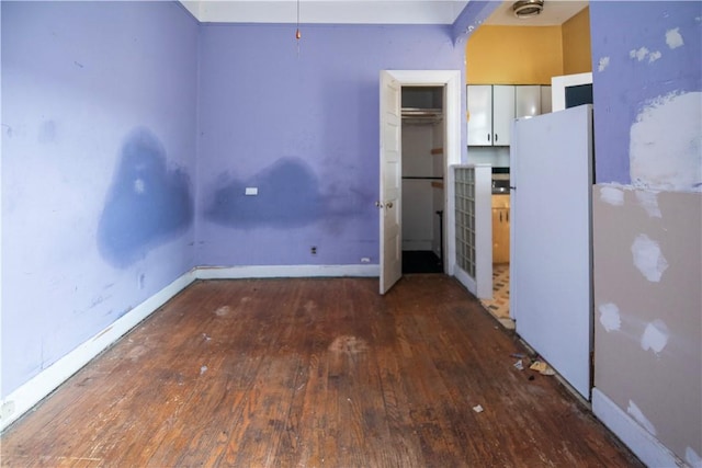 kitchen featuring white cabinets, white fridge, and dark wood-type flooring