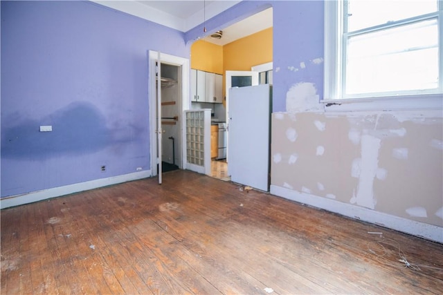 kitchen with white cabinetry, wood-type flooring, and white refrigerator