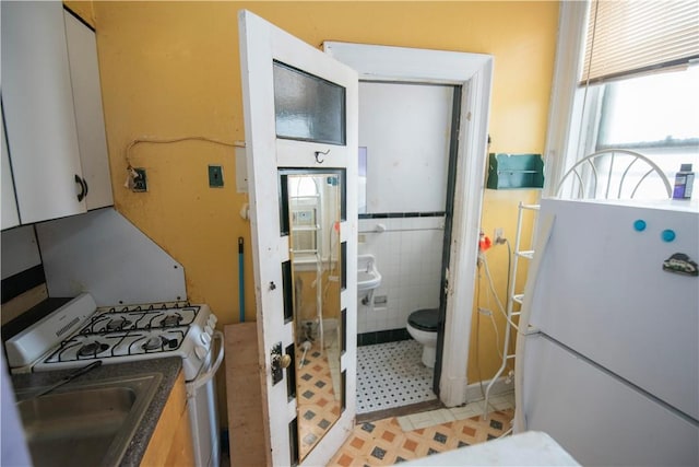 kitchen with white appliances and tile walls