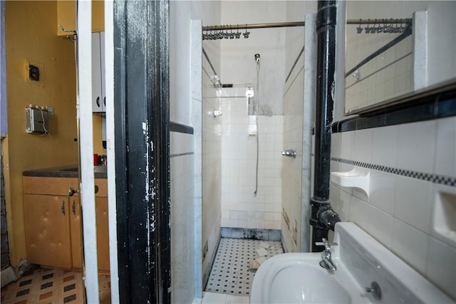 bathroom featuring a tile shower and tile walls