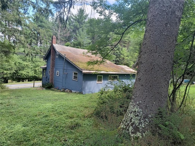 1131 County Route 31, Glen Spey, NY 12737 - view of property exterior featuring a chimney, a lawn, and a wooded view