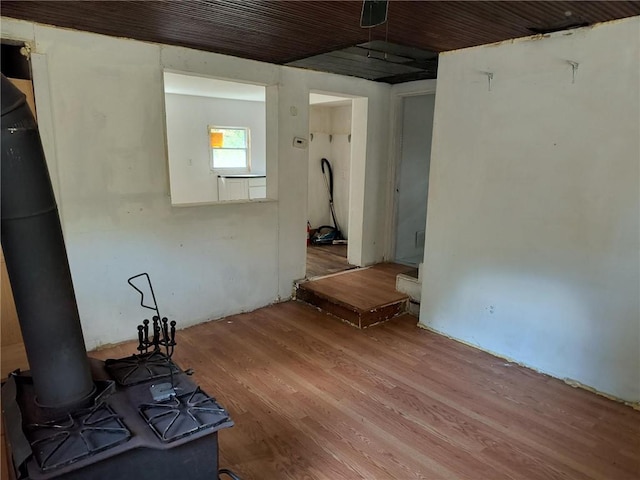 empty room with hardwood / wood-style flooring and a wood stove