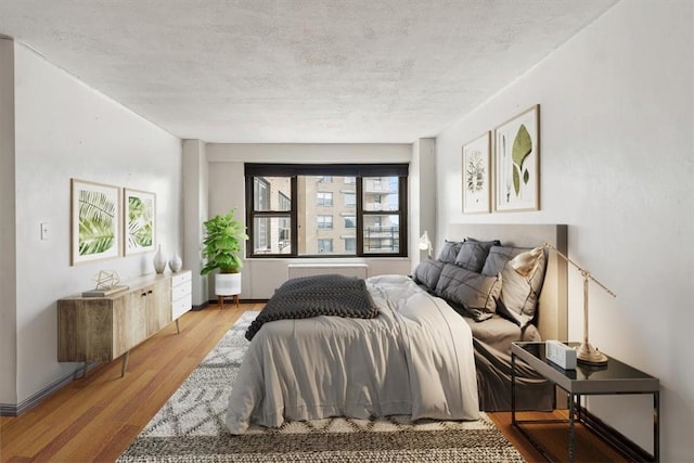 bedroom featuring light hardwood / wood-style flooring and a textured ceiling