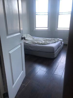 bedroom featuring multiple windows and dark wood-type flooring