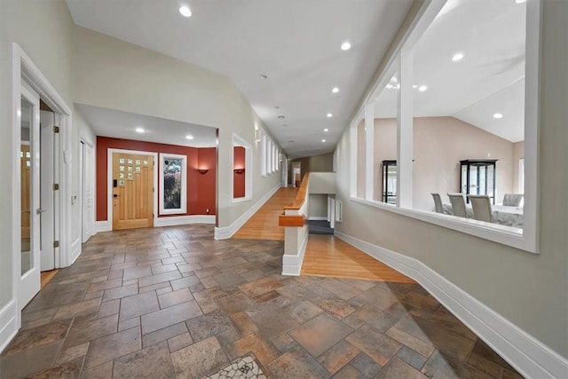 entrance foyer with wood-type flooring and vaulted ceiling