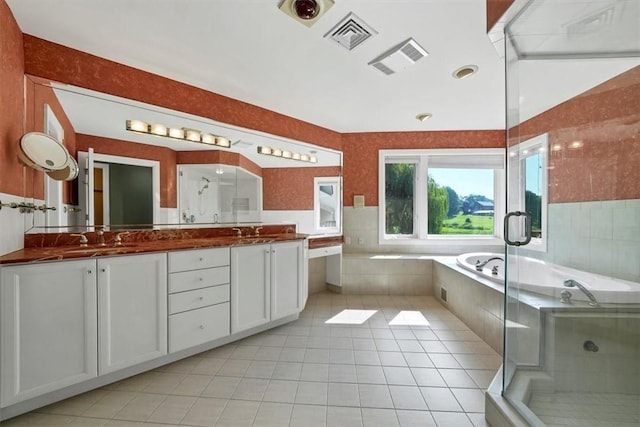 bathroom with tile patterned flooring, vanity, and shower with separate bathtub