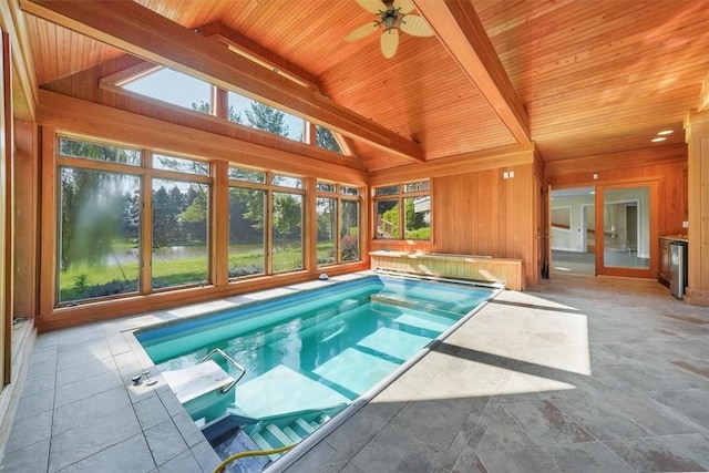 view of swimming pool with ceiling fan, a patio area, and a water view