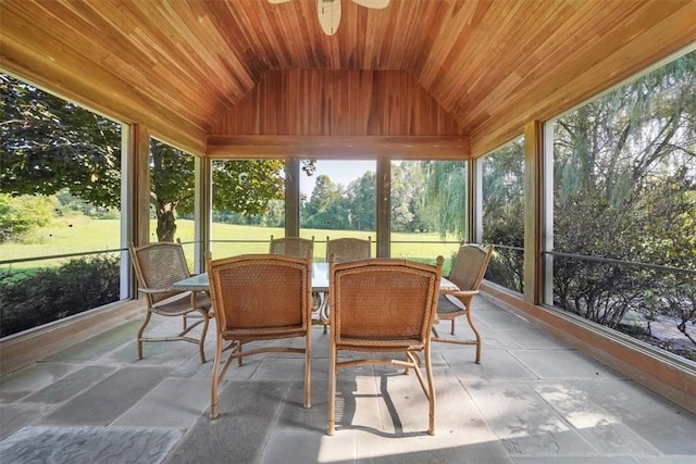 sunroom with ceiling fan, wooden ceiling, a wealth of natural light, and vaulted ceiling