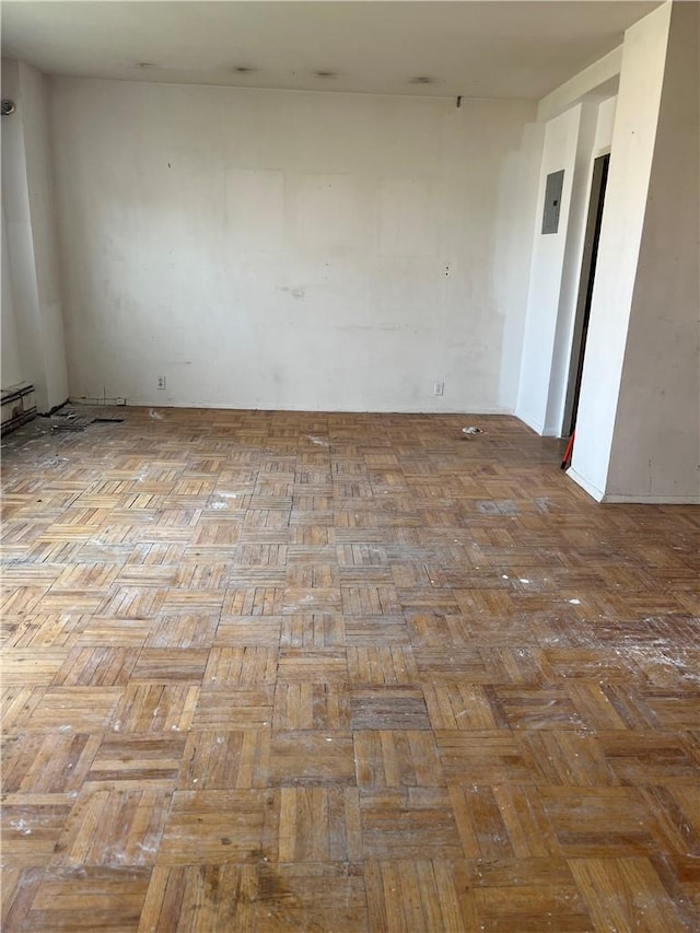 empty room with light parquet flooring and a baseboard heating unit