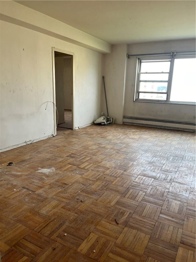 empty room featuring parquet floors and a baseboard radiator