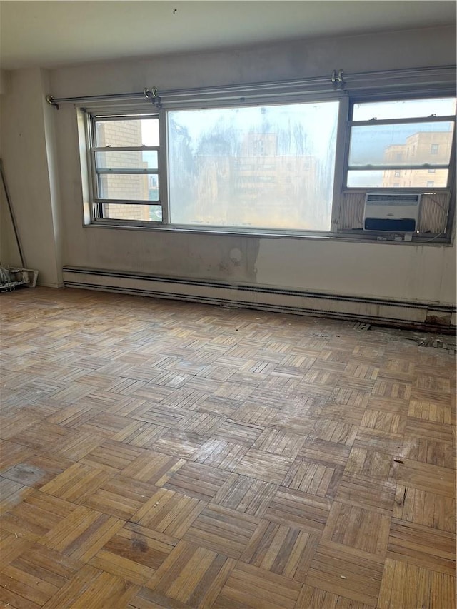 empty room with parquet floors and a baseboard heating unit