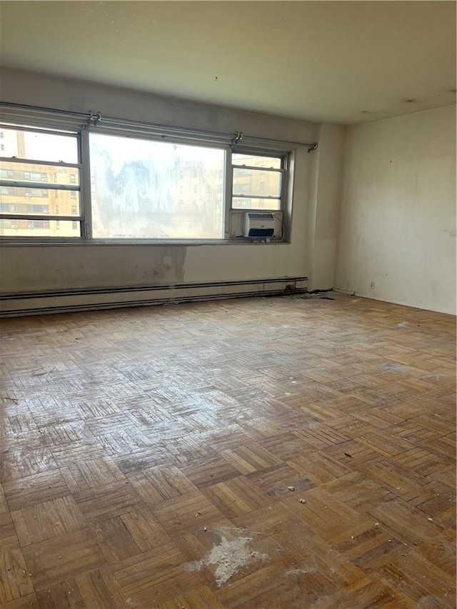 spare room featuring a baseboard radiator, plenty of natural light, and cooling unit