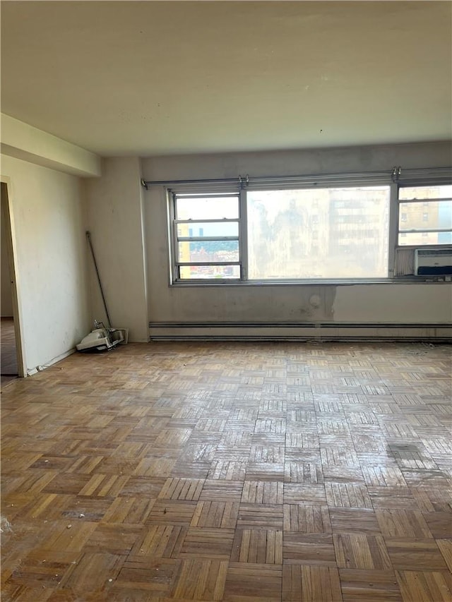 spare room featuring light parquet floors and a baseboard radiator