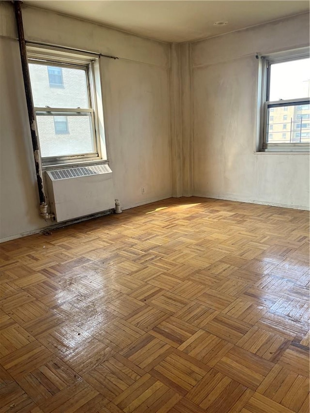 empty room with radiator heating unit and light parquet flooring