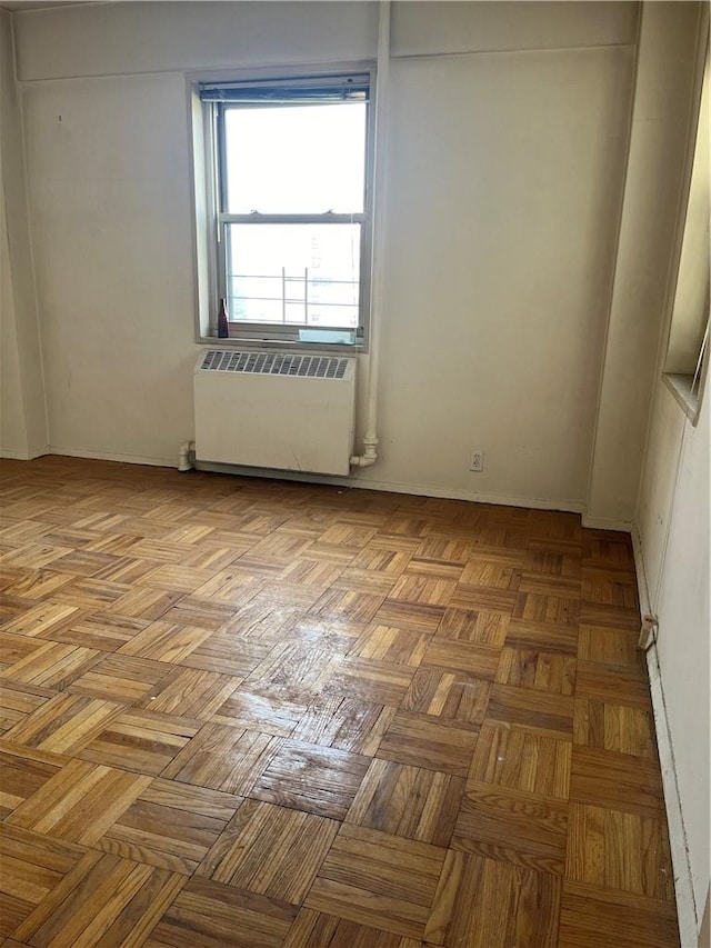 unfurnished room with light parquet flooring and radiator