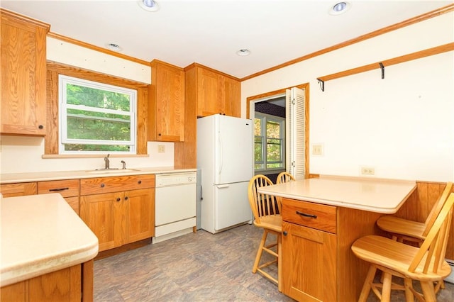 kitchen featuring plenty of natural light, a kitchen bar, white appliances, and sink