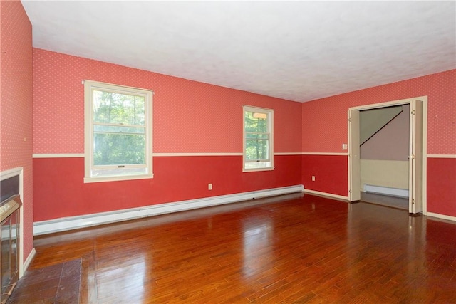 unfurnished room featuring dark hardwood / wood-style floors and baseboard heating