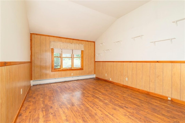 spare room with wooden walls, a baseboard radiator, lofted ceiling, and light hardwood / wood-style floors