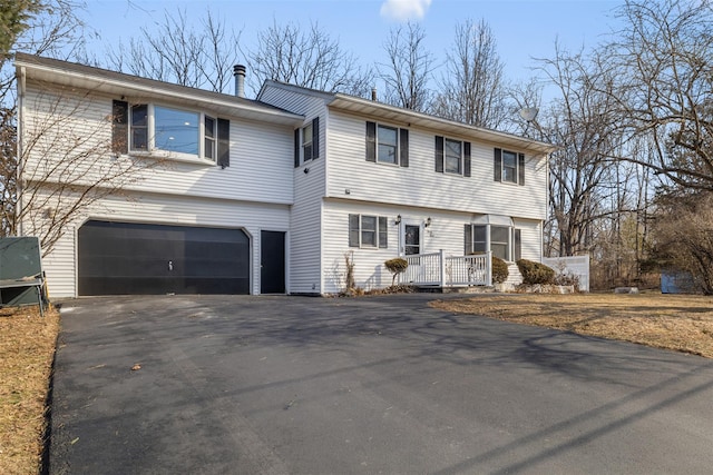 colonial-style house featuring driveway and an attached garage