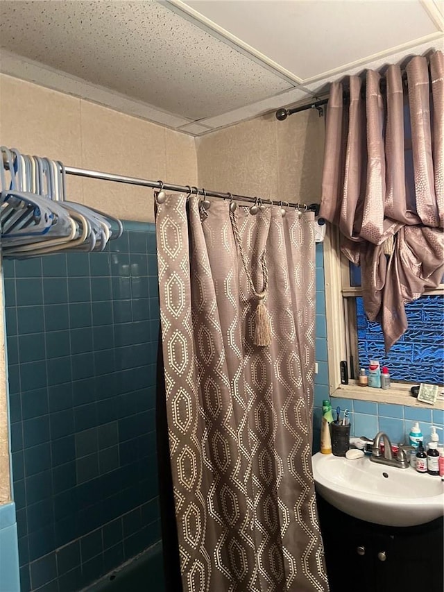 bathroom featuring vanity and tile walls