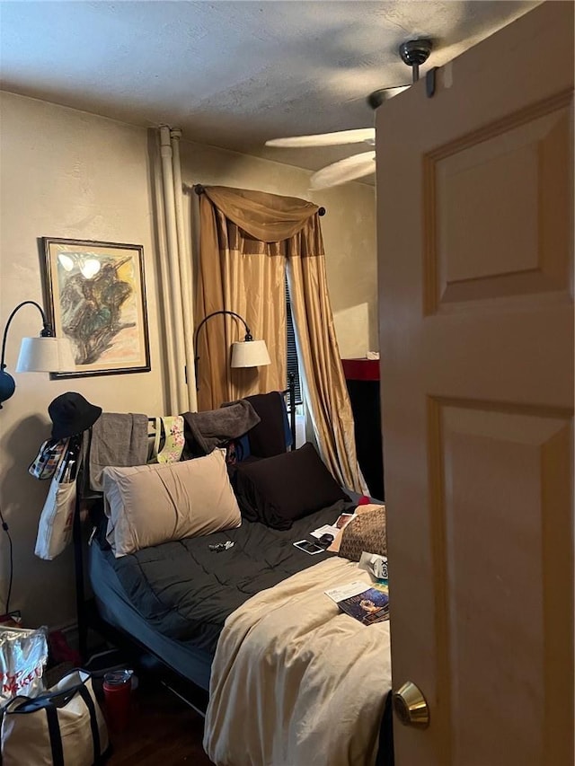 bedroom featuring ceiling fan, wood-type flooring, and a textured ceiling