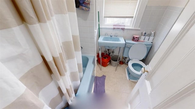 bathroom featuring tile patterned flooring, shower / bath combination with curtain, toilet, and tile walls