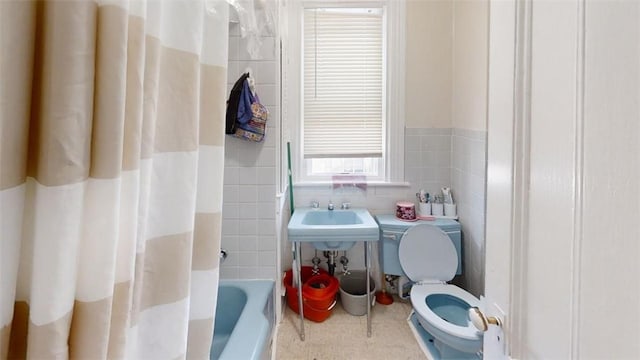 full bathroom with a wealth of natural light, sink, tile walls, and toilet