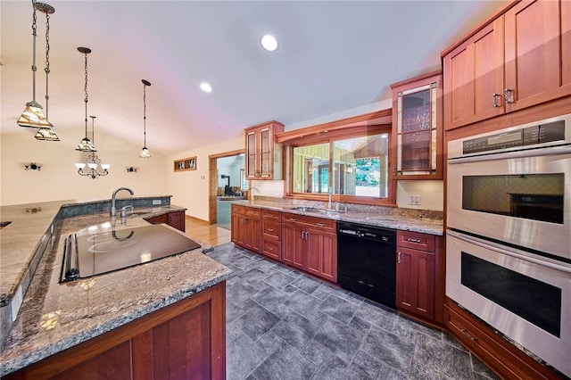 kitchen featuring light stone counters, pendant lighting, black appliances, and sink